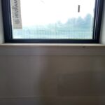 Finished wood window sill installed at interior window opening, raw wood ready for paint.