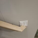 This photo shows a finished wood wall cap installed at the top of a wall, highlighting the craftsmanship and detail of the trim work.