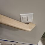 This photo shows a finished wood wall cap installed along a wall, highlighting the craftsmanship and detail of the joinery.