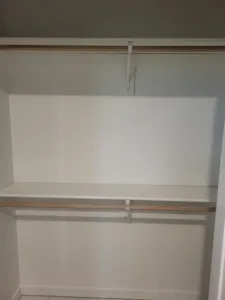 Two tier closet shelving with bullnose particle board shelves and a hanging rod, ready for paint