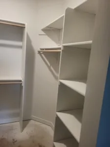 Painted closet shelving with multiple tiers, bullnose shelves, and a hanging rod