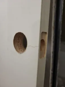 Door face and edge with drilled lockset prep holes, including a through hole and edge bore