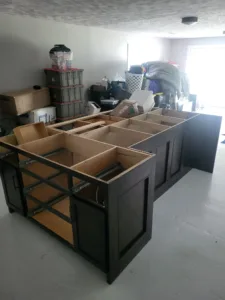 Cabinet boxes mid-install with painted frames and exposed interiors, ready for doors and hardware.