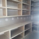 Custom built-in bookcase with white face-frame shelving and open cubbies, ready for paint.