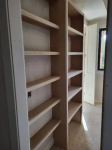 Raw wood closet shelving with multiple shelves on cleats, unfinished, ready for paint