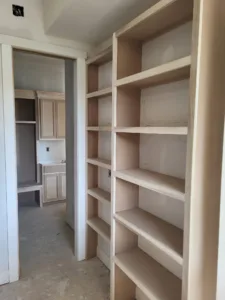 Built-in face-frame wood shelving unit in a closet alcove, raw wood, unpainted.