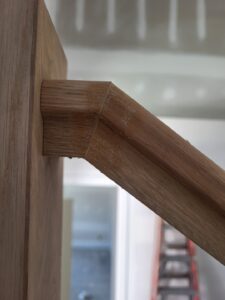 Close-up of a wooden handrail showing the joinery detail and finish quality. This image highlights craftsmanship in stair construction.