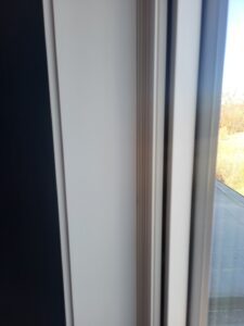 Painted white window casing installed on interior side of window frame, standard height.