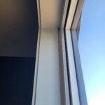 Finished exterior door frame with painted casing, jamb, and weatherstrip installed.