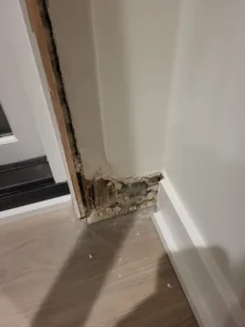 Incorrect: unfinished jamb base with rough patched drywall and a visible gap at the corner.