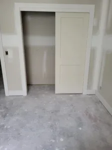 Single white painted door open into an empty closet, no exposed barn track hardware visible
