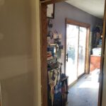 Finished wood cased opening with stained jamb and mitered casing, no door slab—interior pass-through opening.