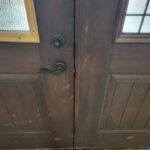 Pair of stained French doors meeting at center with black hardware and lever handles installed.