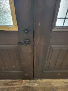 Stained French doors meeting at center stiles with dark lever handles and hardware, completed