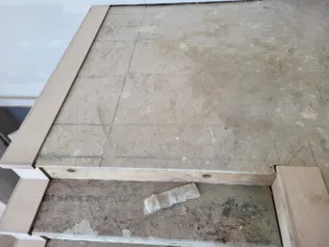 Raw wood frame with visible fasteners and seams, pre-finish stage.