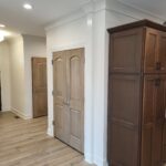 Multiple interior doors and closet bi-fold installed with white painted casing and trim in finished basement space.
