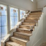 Finished stair skirt boards installed on both sides of staircase with raw wood treads and risers, ready for paint.