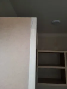Large boxed wood column or corner element with an open shelf structure visible alongside it.