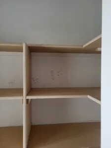 Incorrect: pencil layout marks left visible on the front face of unfinished closet shelf boards
