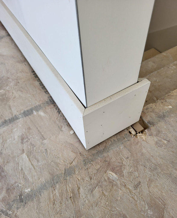 White baseboard joined at an outside corner beside a stair opening.