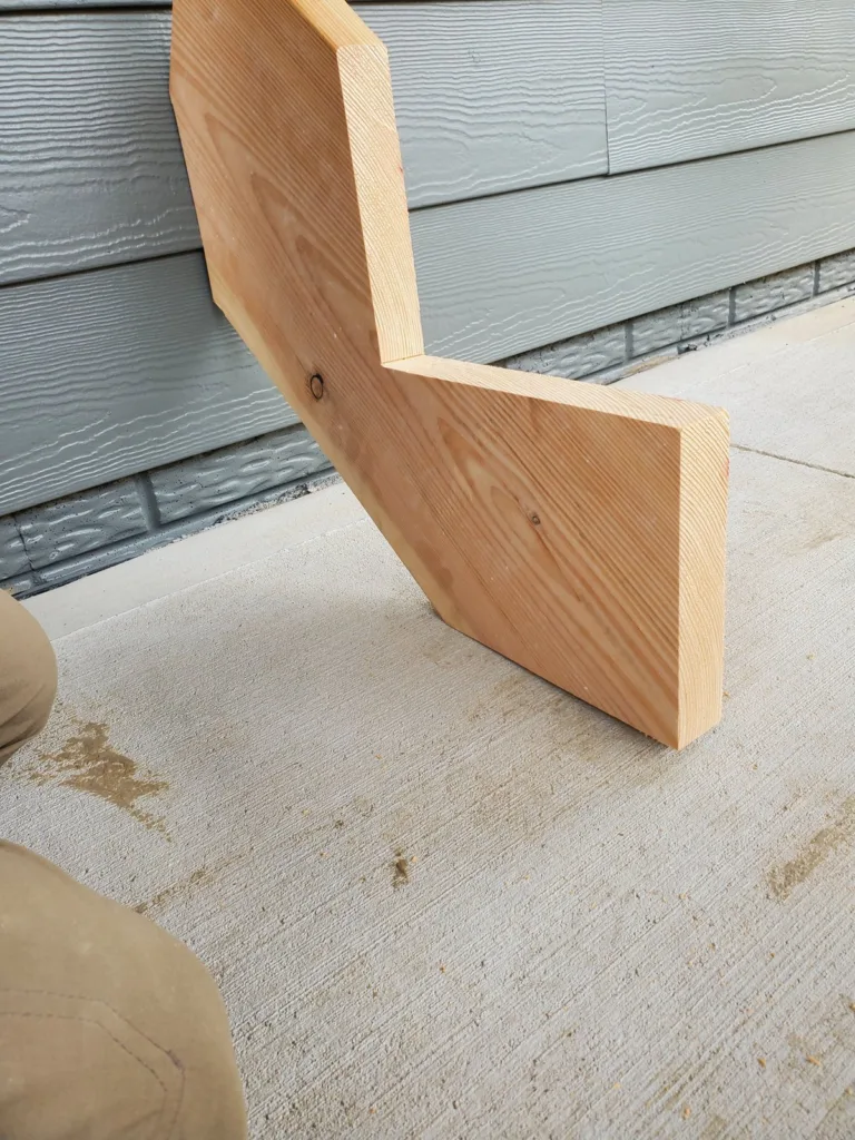 First cut stringer with two notches standing on the patio slab against the house siding