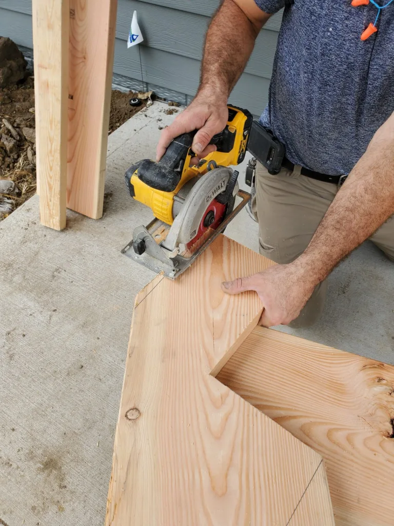 Circular saw cutting the second stringer, the first stringer standing against the house behind it