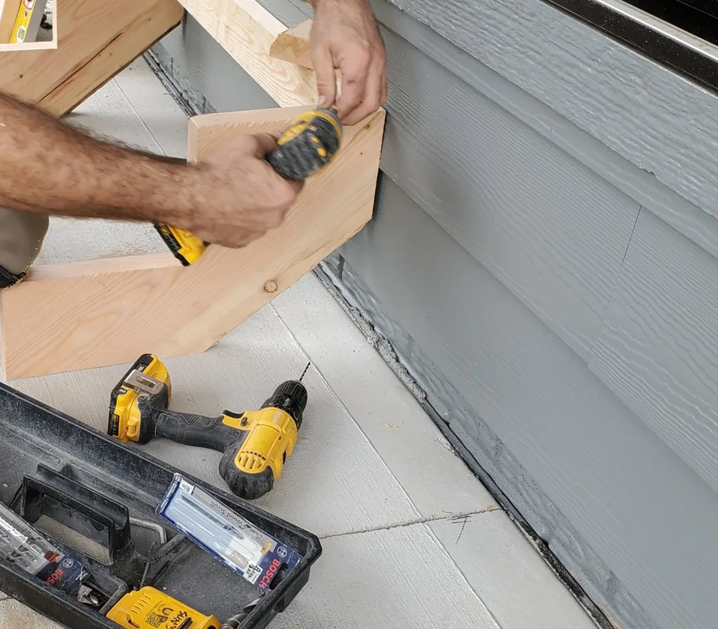Stringer and back board frame set against the house siding while it is fastened at the top