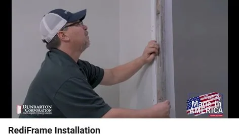 Installer checks the hinge jamb vertically with a level before fastening the lower end.